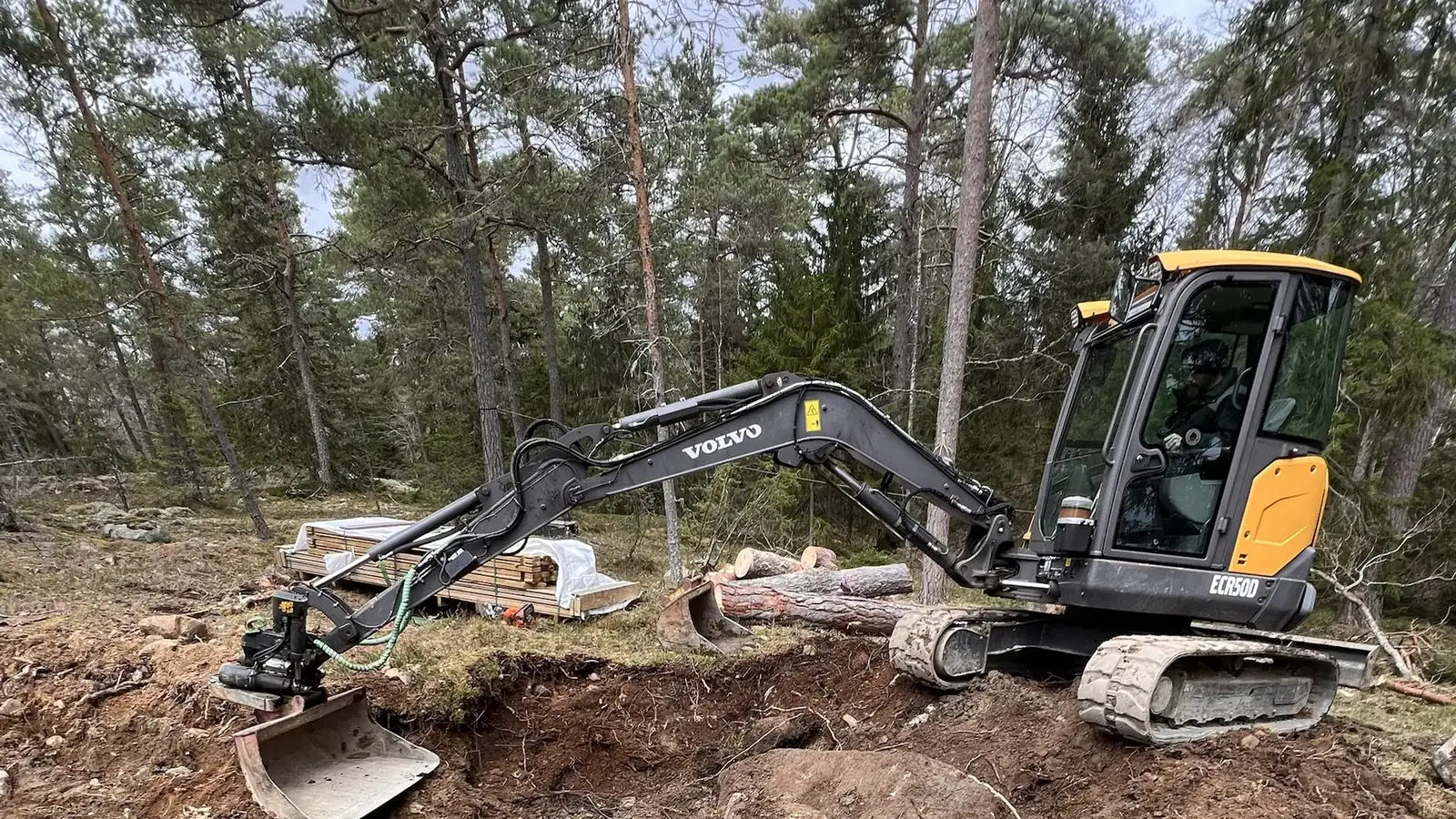 Norrhörnets Volvo ECR50D gräver för avlopp i skogsmark